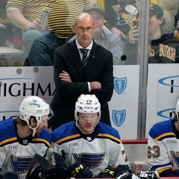 FILE - St. Louis Blues head coach Drew Bannister stands behind the bench during the first period of an NHL hockey game against the Pittsburgh Penguins, Dec. 30, 2023, in Pittsburgh. (AP Photo/Matt Freed, File)