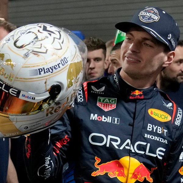 Red Bull driver Max Verstappen, of the Netherlands, looks at a helmet given to him by his team after winning the Formula 1 championship with his team after the F1 Las Vegas Grand Prix auto race, Sunday, Nov. 24, 2024, in Las Vegas. (AP Photo/Matt York)