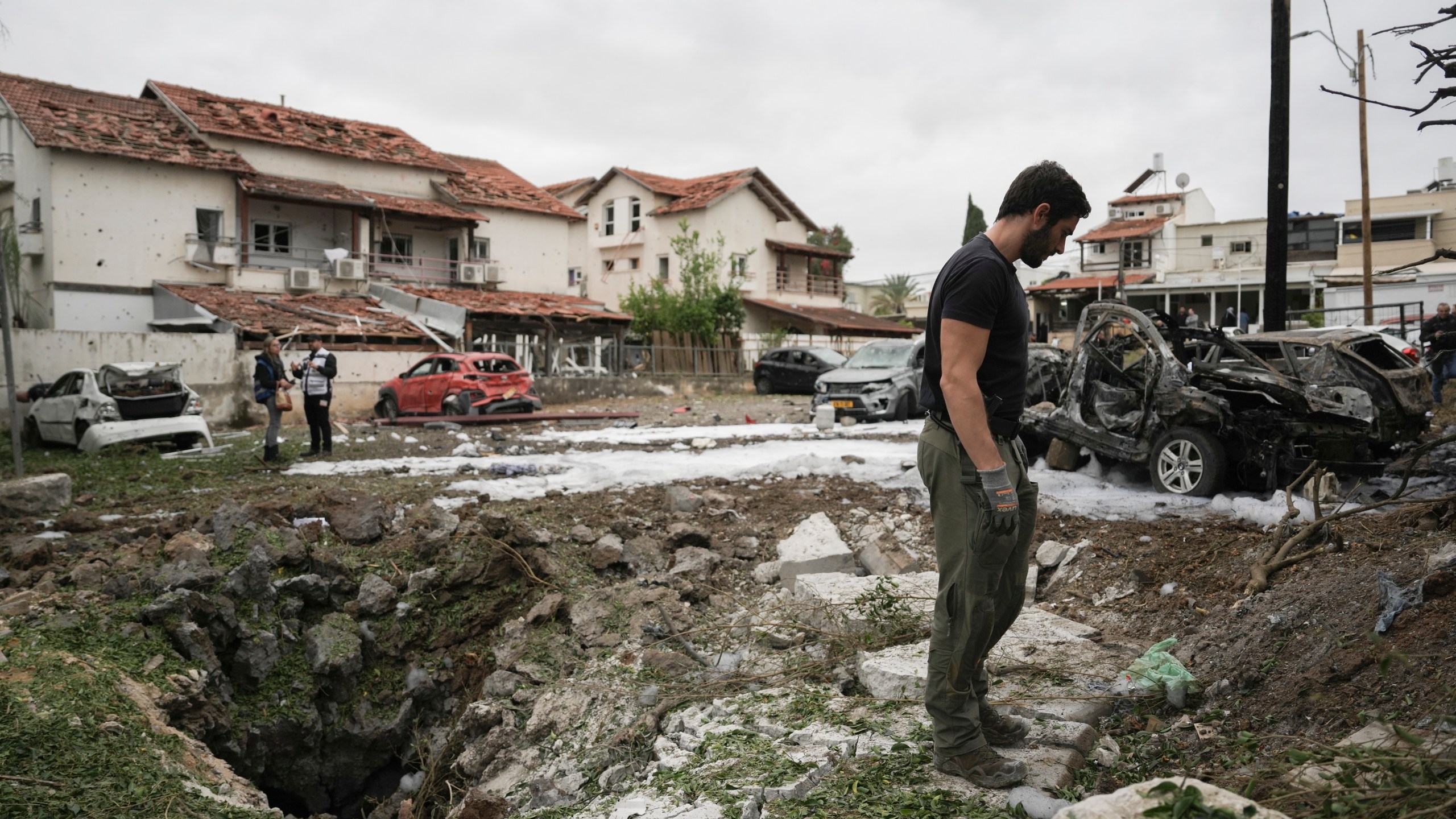 Israeli police bomb squad inspect the site after a missile fired from Lebanon hit the area in Petah Tikva, outskirts of Tel Aviv, Israel, Sunday Nov. 24, 2024. (AP Photo/Oded Balilty)