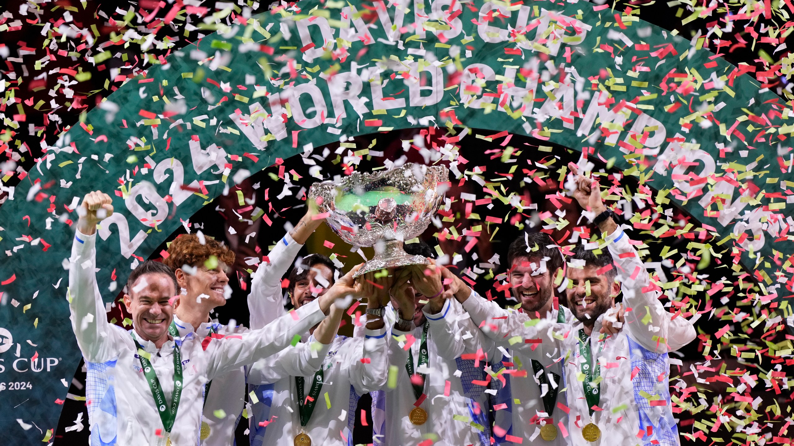 Italian tennis team members hold the Davis Cup trophy after the final between Netherlands and Italy at the Martin Carpena Sports Hall in Malaga, southern Spain, as Italy wins its second consecutive Davis Cup title, Sunday, Nov. 24, 2024. (AP Photo/Manu Fernandez)