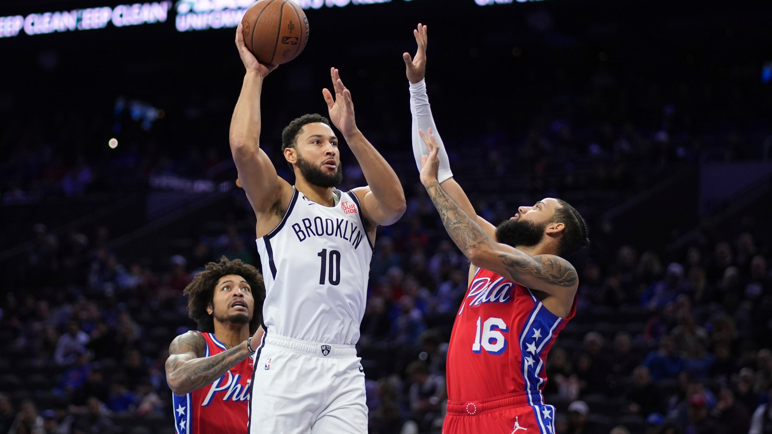 Brooklyn Nets' Ben Simmons, center, goes up for a shot between Philadelphia 76ers' Caleb Martin, right, and Kelly Oubre Jr. during the first half of an Emirates NBA Cup basketball game, Friday, Nov. 22, 2024, in Philadelphia. (AP Photo/Matt Slocum)