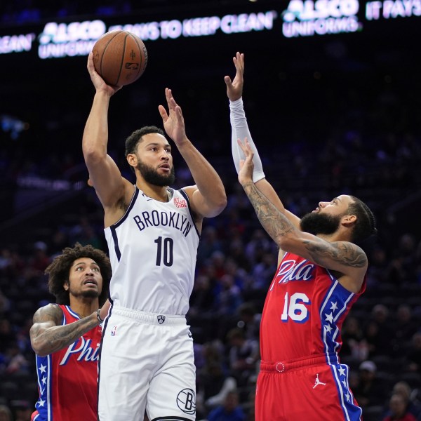 Brooklyn Nets' Ben Simmons, center, goes up for a shot between Philadelphia 76ers' Caleb Martin, right, and Kelly Oubre Jr. during the first half of an Emirates NBA Cup basketball game, Friday, Nov. 22, 2024, in Philadelphia. (AP Photo/Matt Slocum)