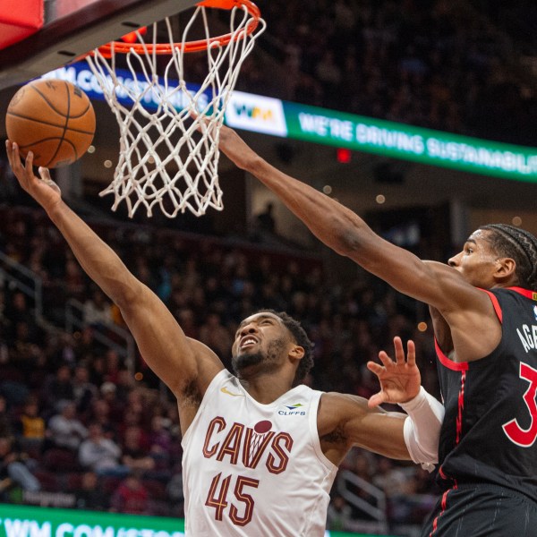 Cleveland Cavaliers' Donovan Mitchell (45) shoots as Toronto Raptors' Ochai Agbaji (30) defends during the second half of an NBA basketball game in Cleveland, Sunday, Nov 24, 2024. (AP Photo/Phil Long)