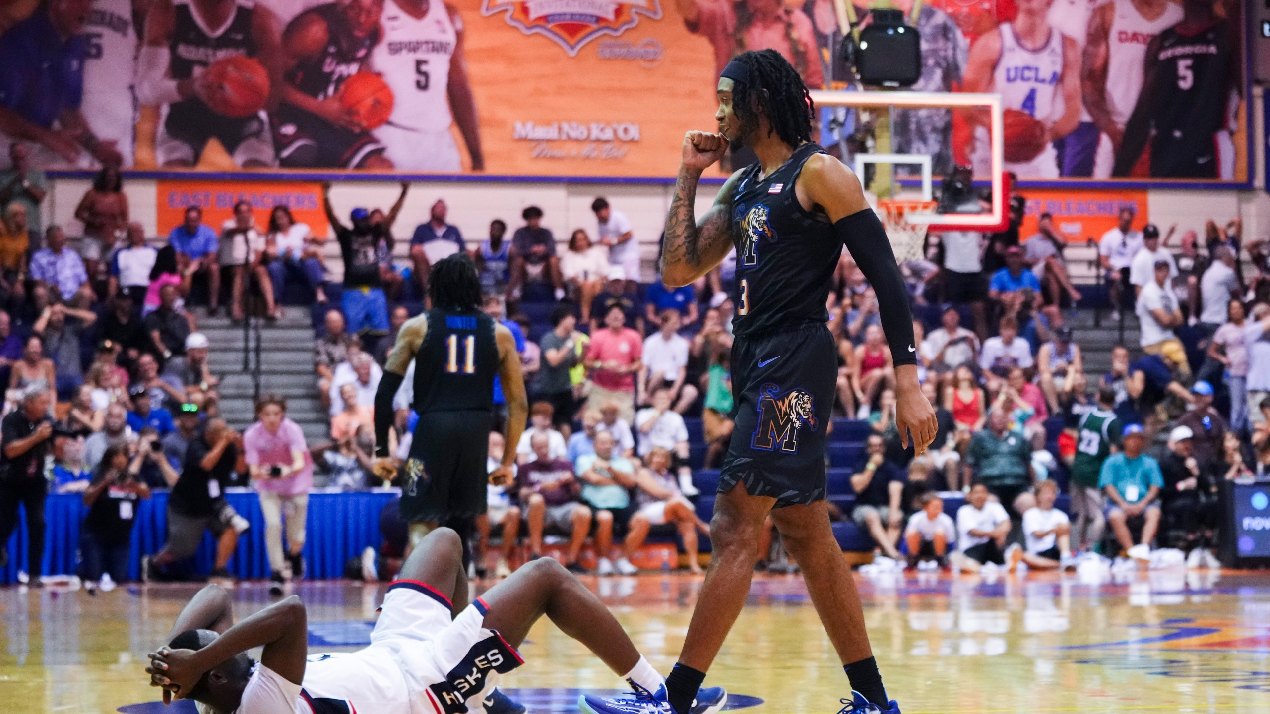 Memphis guard Colby Rogers, right, celebrates a 99-97 win in overtime as UConn guard Hassan Diarra, left, lies on the ground in an NCAA college basketball game at the Maui Invitational Monday, Nov. 25, 2024, in Lahaina, Hawaii. (AP Photo/Lindsey Wasson)