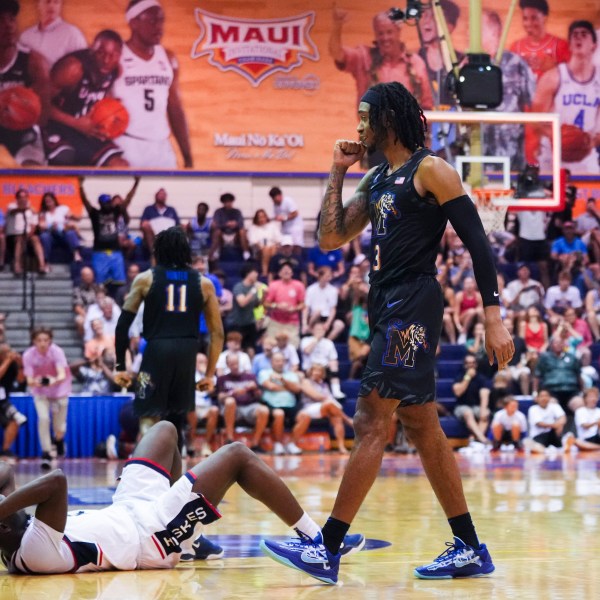 Memphis guard Colby Rogers, right, celebrates a 99-97 win in overtime as UConn guard Hassan Diarra, left, lies on the ground in an NCAA college basketball game at the Maui Invitational Monday, Nov. 25, 2024, in Lahaina, Hawaii. (AP Photo/Lindsey Wasson)