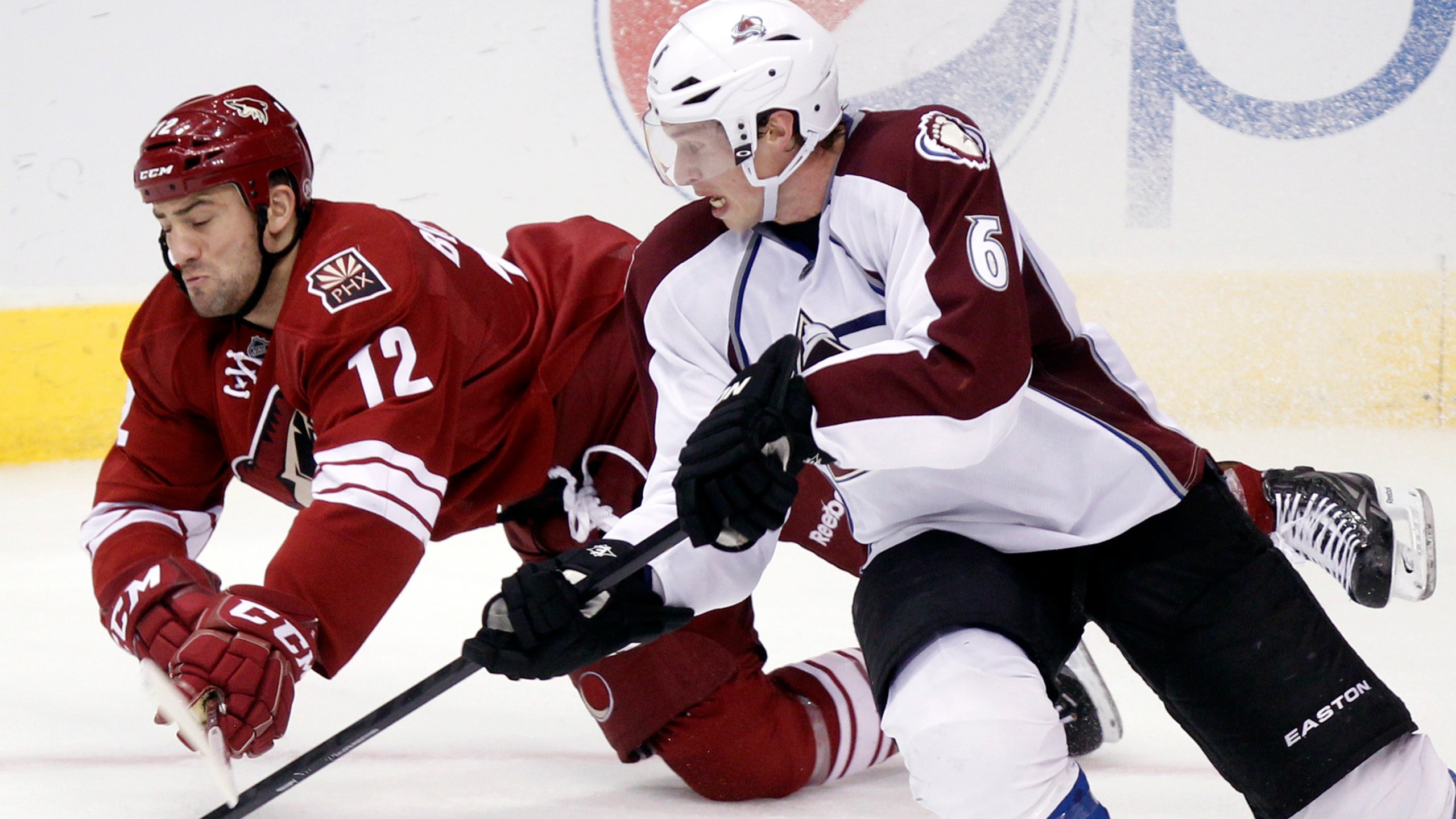 FILE - Phoenix Coyotes left winger Paul Bissonnette, left, and Colorado Avalanche defenseman Erik Johnson, right, compete for the puck in the third period of an NHL hockey game, April 6, 2013, in Glendale, Ariz. (AP Photo/Paul Connors, File)