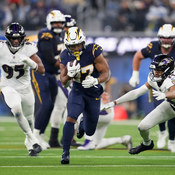 Los Angeles Chargers running back J.K. Dobbins (27) runs past Baltimore Ravens safety Kyle Hamilton (14) during the first half of an NFL football game Monday, Nov. 25, 2024, in Inglewood, Calif. (AP Photo/Eric Thayer)