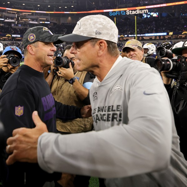 Baltimore Ravens Head Coach John Harbaugh, left, hugs Los Angeles Chargers head coach Jim Harbaugh after an NFL football game Monday, Nov. 25, 2024, in Inglewood, Calif. (AP Photo/Ryan Sun)