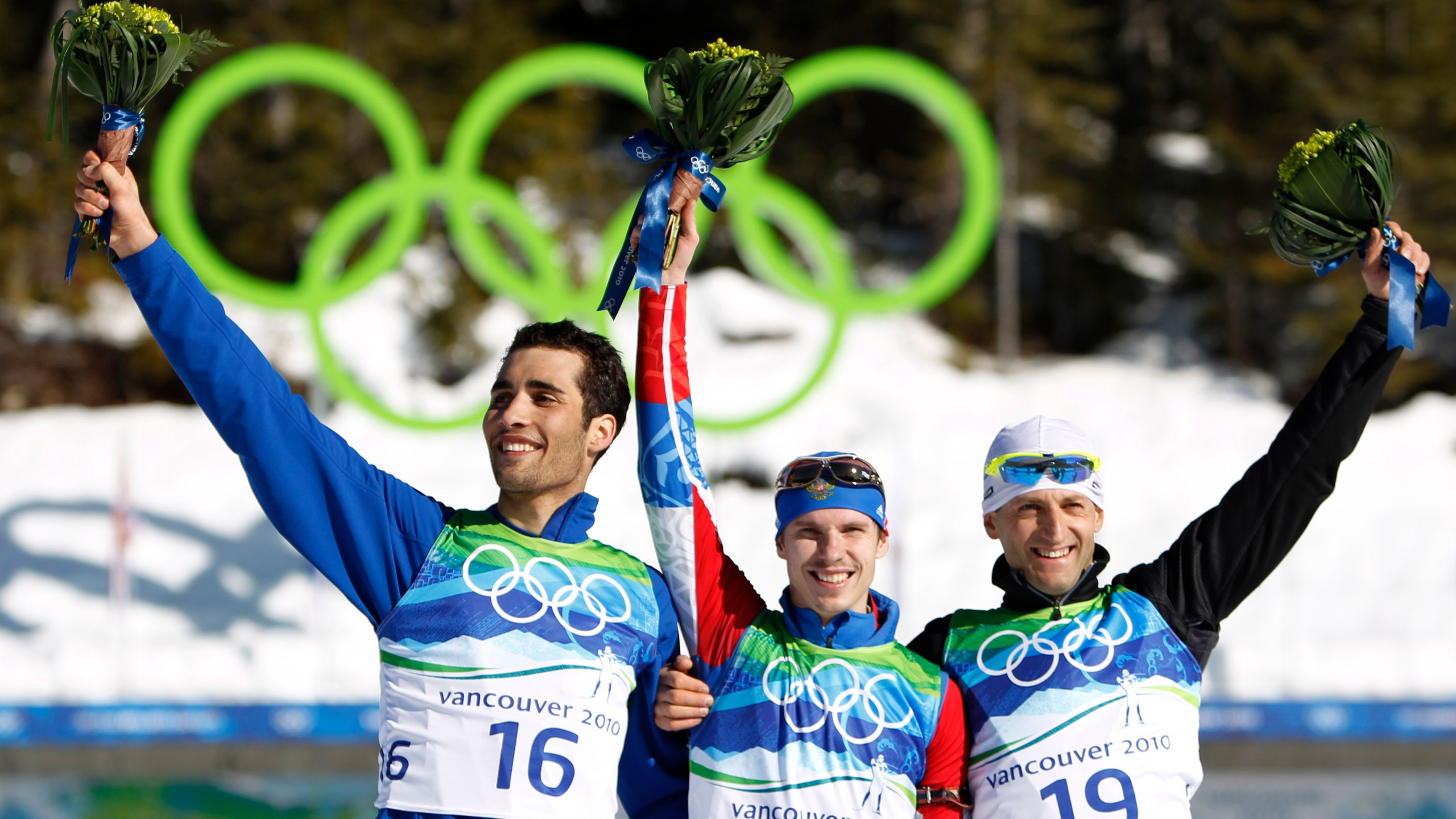 FILE - Gold medallist Russia's Evgeny Ustyugov, center, jubilates with silver medallist Martin Fourcade of France, left, and bronze medallist Slovakia's Pavol Hurajt during the flower ceremony after winning the men's 15 km biathlon mass start at the Vancouver 2010 Olympics in Whistler, British Columbia, Sunday, Feb. 21, 2010. (AP Photo/Matthias Schrader, File)