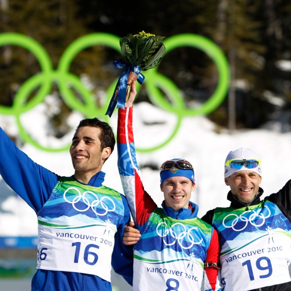 FILE - Gold medallist Russia's Evgeny Ustyugov, center, jubilates with silver medallist Martin Fourcade of France, left, and bronze medallist Slovakia's Pavol Hurajt during the flower ceremony after winning the men's 15 km biathlon mass start at the Vancouver 2010 Olympics in Whistler, British Columbia, Sunday, Feb. 21, 2010. (AP Photo/Matthias Schrader, File)