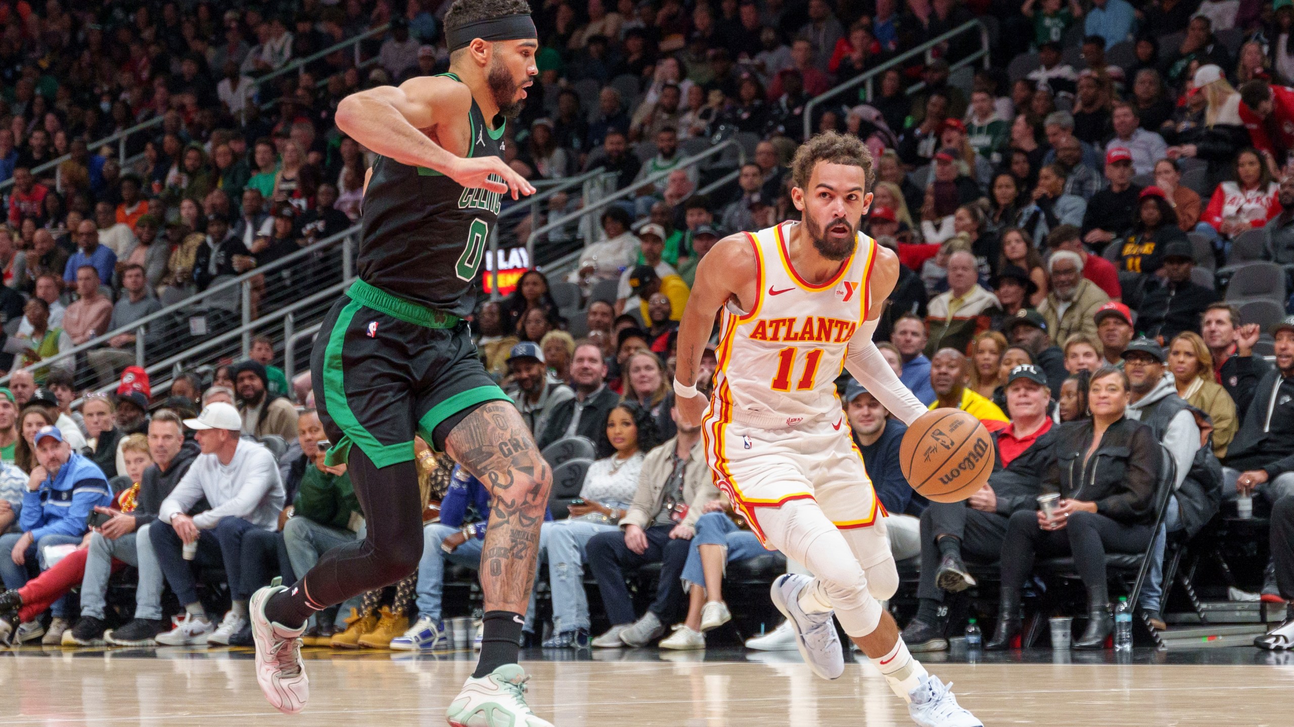 Atlanta Hawks guard Trae Young (11) drives the lane while guarded by Boston Celtics forward Jayson Tatum (0) during the first half of an NBA basketball game, Monday, Nov. 4, 2024, in Atlanta. (AP Photo/Jason Allen)