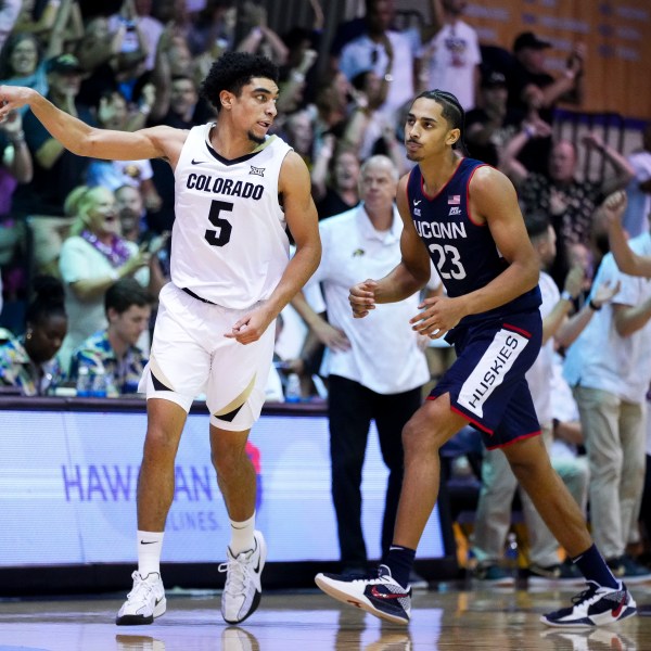 Colorado guard RJ Smith (5) reacts after a basket as UConn forward Jayden Ross (23) looks on during the second half of an NCAA college basketball game at the Maui Invitational Tuesday, Nov. 26, 2024, in Lahaina, Hawaii. Colorado won 73-72. (AP Photo/Lindsey Wasson)