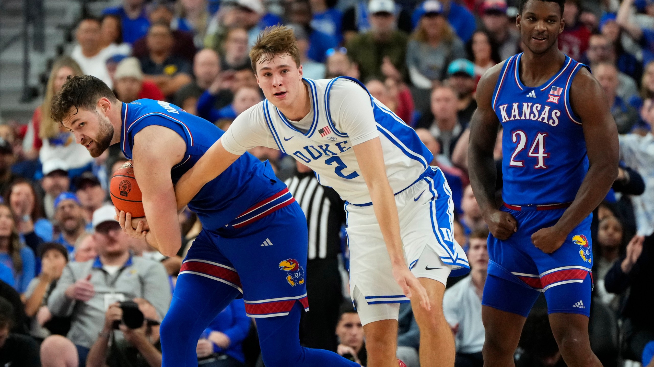 Kansas guard Caleb Foster, left, battles for the ball against Duke guard/forward Cooper Flagg (2) during the first half of an NCAA college basketball game Tuesday, Nov. 26, 2024, in Las Vegas. (AP Photo/Lucas Peltier)