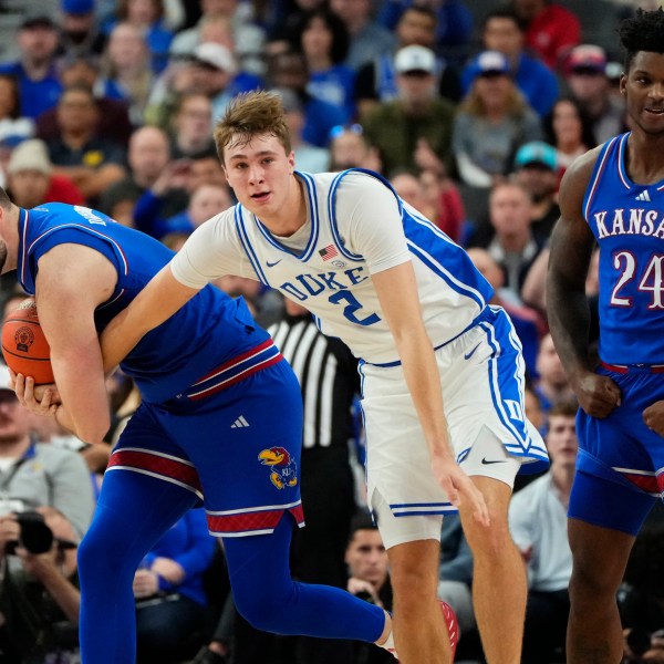 Kansas guard Caleb Foster, left, battles for the ball against Duke guard/forward Cooper Flagg (2) during the first half of an NCAA college basketball game Tuesday, Nov. 26, 2024, in Las Vegas. (AP Photo/Lucas Peltier)