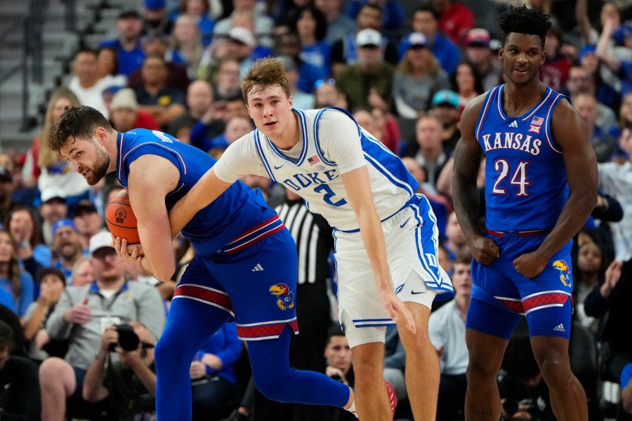 Kansas guard Caleb Foster, left, battles for the ball against Duke guard/forward Cooper Flagg (2) during the first half of an NCAA college basketball game Tuesday, Nov. 26, 2024, in Las Vegas. (AP Photo/Lucas Peltier)