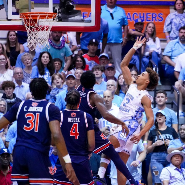 North Carolina guard Seth Trimble (7) scores against Auburn guard JP Pegues during the first half of an NCAA college basketball game at the Maui Invitational Tuesday, Nov. 26, 2024, in Lahaina, Hawaii. (AP Photo/Lindsey Wasson)