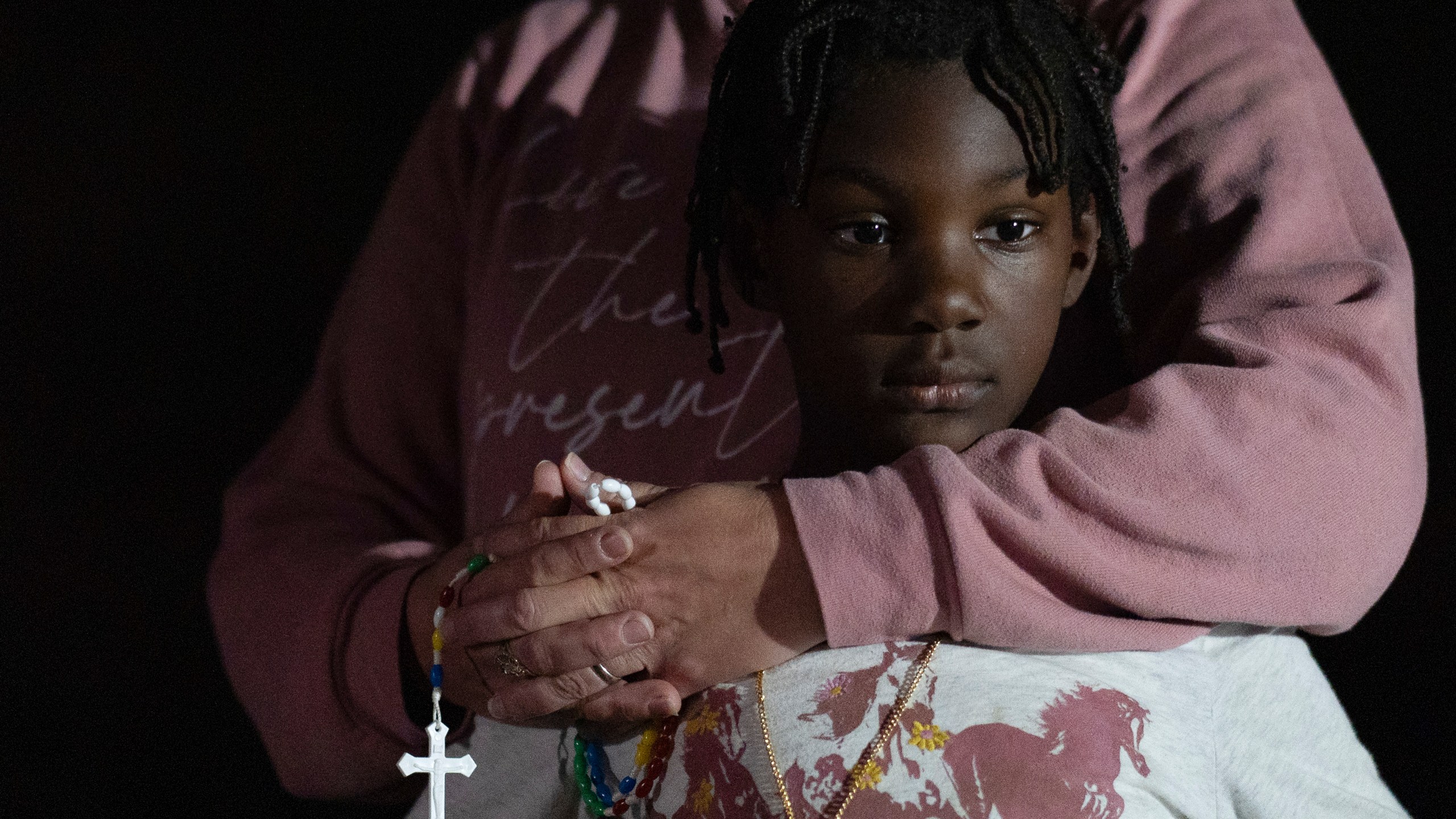 Erin Young holds her adopted daughter Gianna Young, 7, as she prays the "Patriotic Rosary" for the consecration of the nation and Donald Trump with family and members of their Catholic church around a bonfire at their home the night before the election, Monday, Nov. 4, 2024, in Sunbury, Ohio. (AP Photo/Carolyn Kaster)