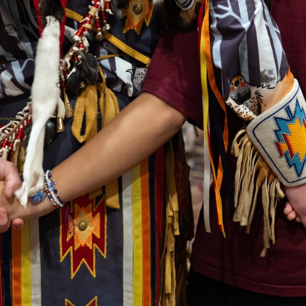 People hold hands during a dance at a powwow at Chinook Winds Casino Resort, Saturday, Nov. 16, 2024, in Lincoln City, Ore. (AP Photo/Jenny Kane)