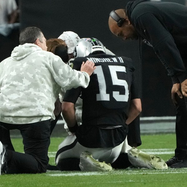 Las Vegas Raiders quarterback Gardner Minshew (15) is assisted by trainers and Head Coach Antonio Pierce, right, after an injury during the second half of an NFL football game against the Denver Broncos, Sunday, Nov. 24, 2024, in Las Vegas. (AP Photo/Rick Scuteri)