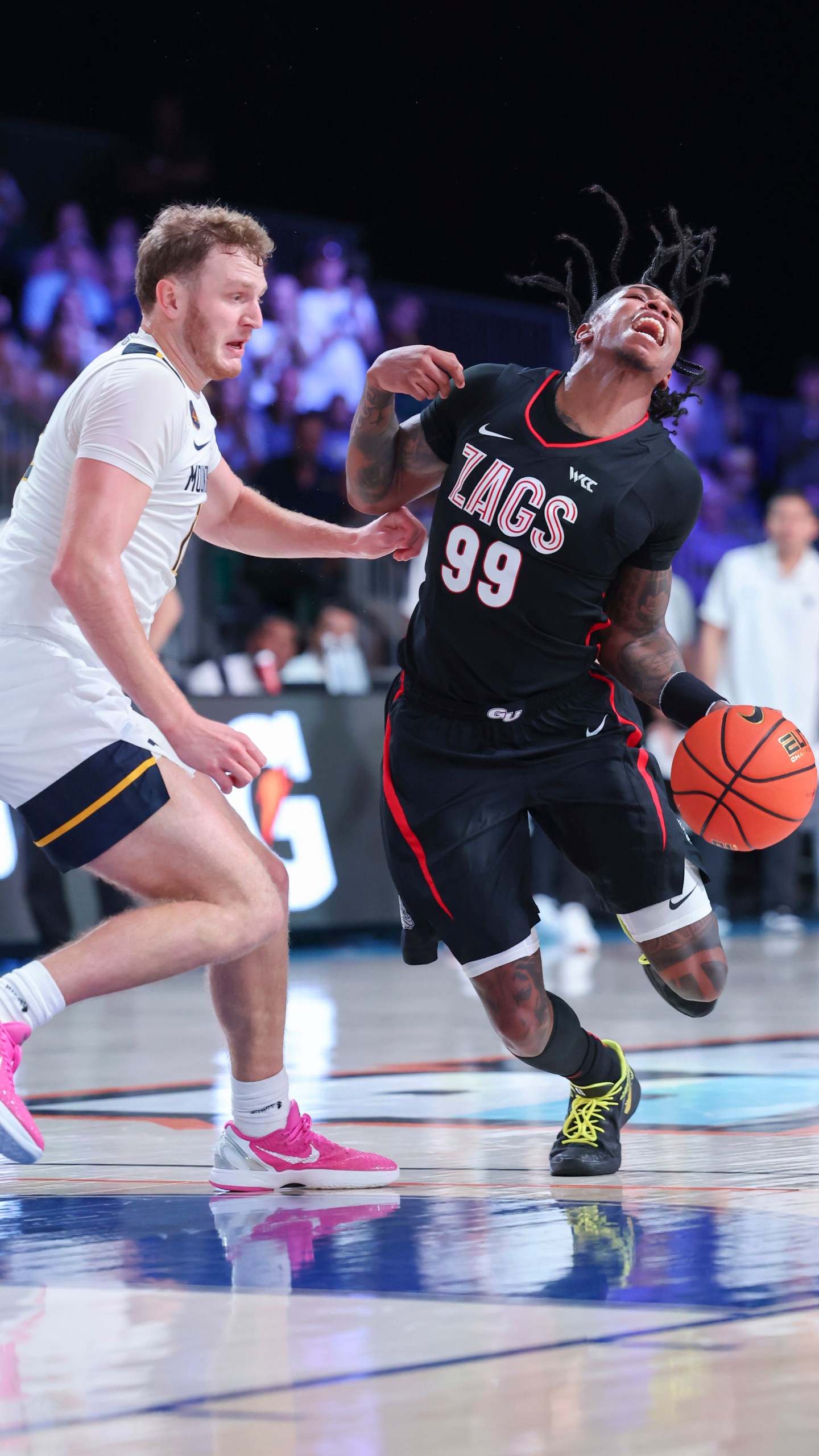 In this handout provided by Bahamas Visual Services, Gonzaga guard Khalif Battle (99) drives against West Virginia guard Tucker DeVries, left, during an NCAA college basketball game at the Battle 4 Atlantis tournament in Paradise Island, Bahamas Wednesday, Nov. 27, 2024. (Tim Aylen/Bahamas Visual Services via AP)