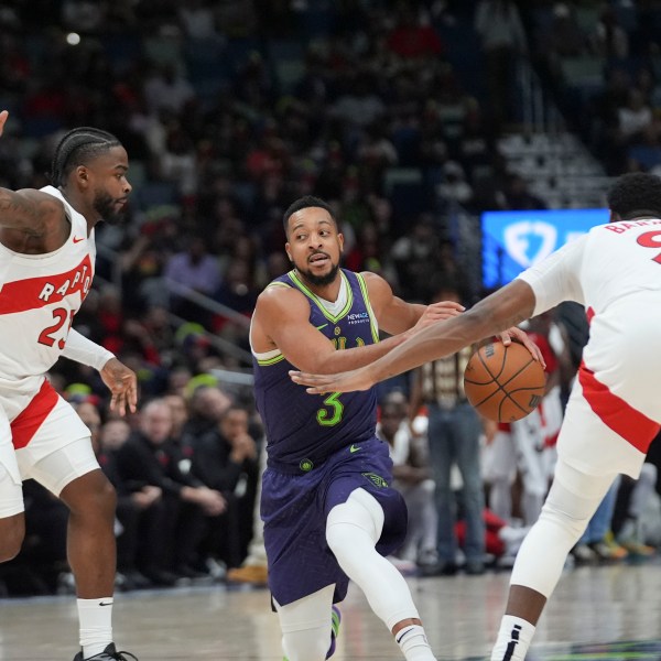 New Orleans Pelicans guard CJ McCollum (3) drives to the basket between Toronto Raptors guard Jamal Shead and guard RJ Barrett (9) in the second half of an NBA basketball game in New Orleans, Wednesday, Nov. 27, 2024. The Raptors won 119-93. (AP Photo/Gerald Herbert)