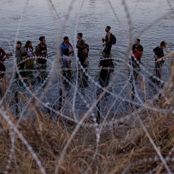 FILE - Migrants wait to climb over concertina wire after they crossed the Rio Grande and entered the U.S. from Mexico, Sept. 23, 2023, in Eagle Pass, Texas. (AP Photo/Eric Gay, File)