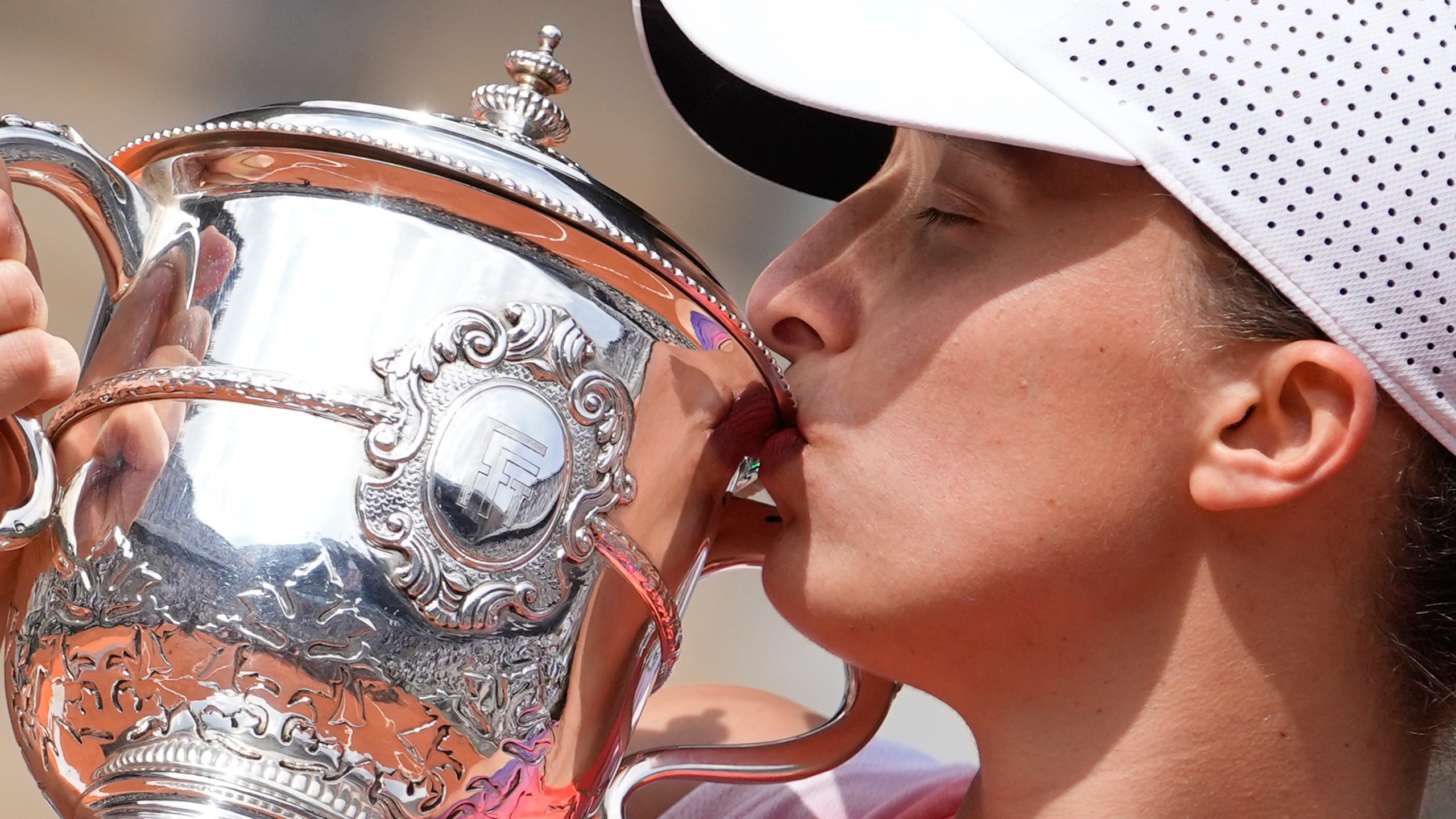 FILE - Poland's Iga Swiatek kisses the trophy after winning the women's final of the French Open tennis tournament against Italy's Jasmine Paolini at the Roland Garros stadium in Paris, France, Saturday, June 8, 2024. (AP Photo/Thibault Camus, File)