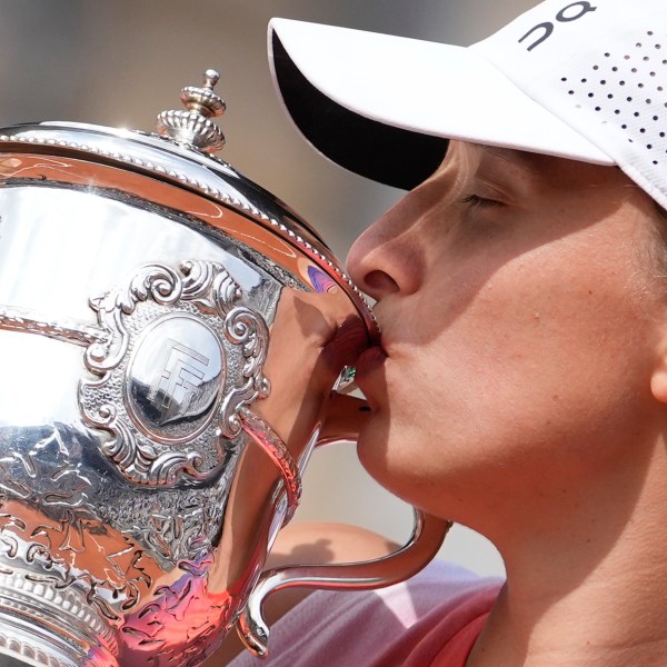 FILE - Poland's Iga Swiatek kisses the trophy after winning the women's final of the French Open tennis tournament against Italy's Jasmine Paolini at the Roland Garros stadium in Paris, France, Saturday, June 8, 2024. (AP Photo/Thibault Camus, File)