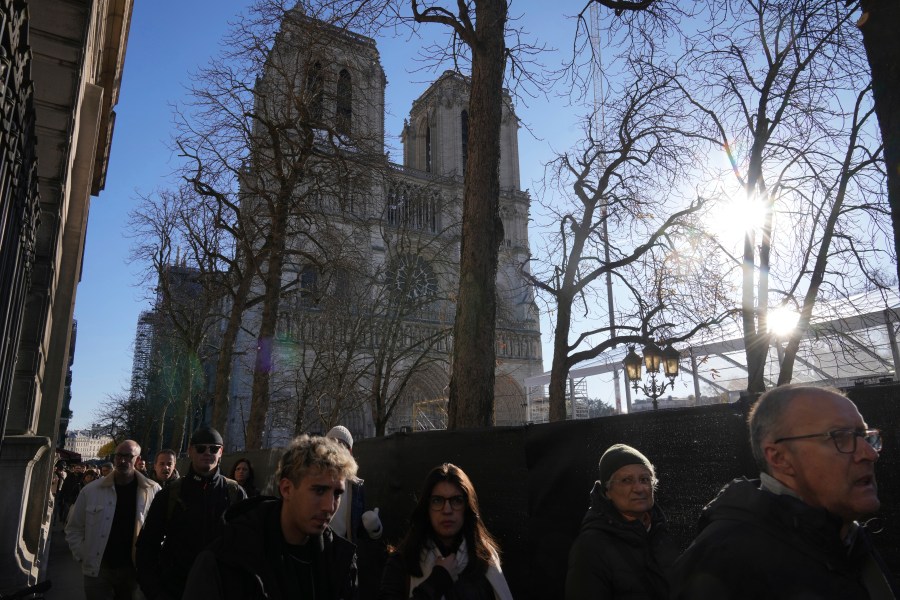 People walk by a security perimeter next to Notre-Dame cathedral, Thursday, Nov. 28, 2024 in Paris. (AP Photo/Michel Euler)