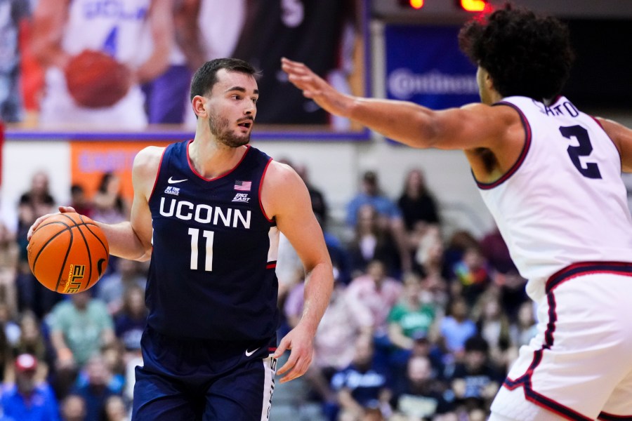 UConn forward Alex Karaban (11) looks to pass around Dayton forward Nate Santos (2) during the first half of an NCAA college basketball game at the Maui Invitational Wednesday, Nov. 27, 2024, in Lahaina, Hawaii. (AP Photo/Lindsey Wasson)