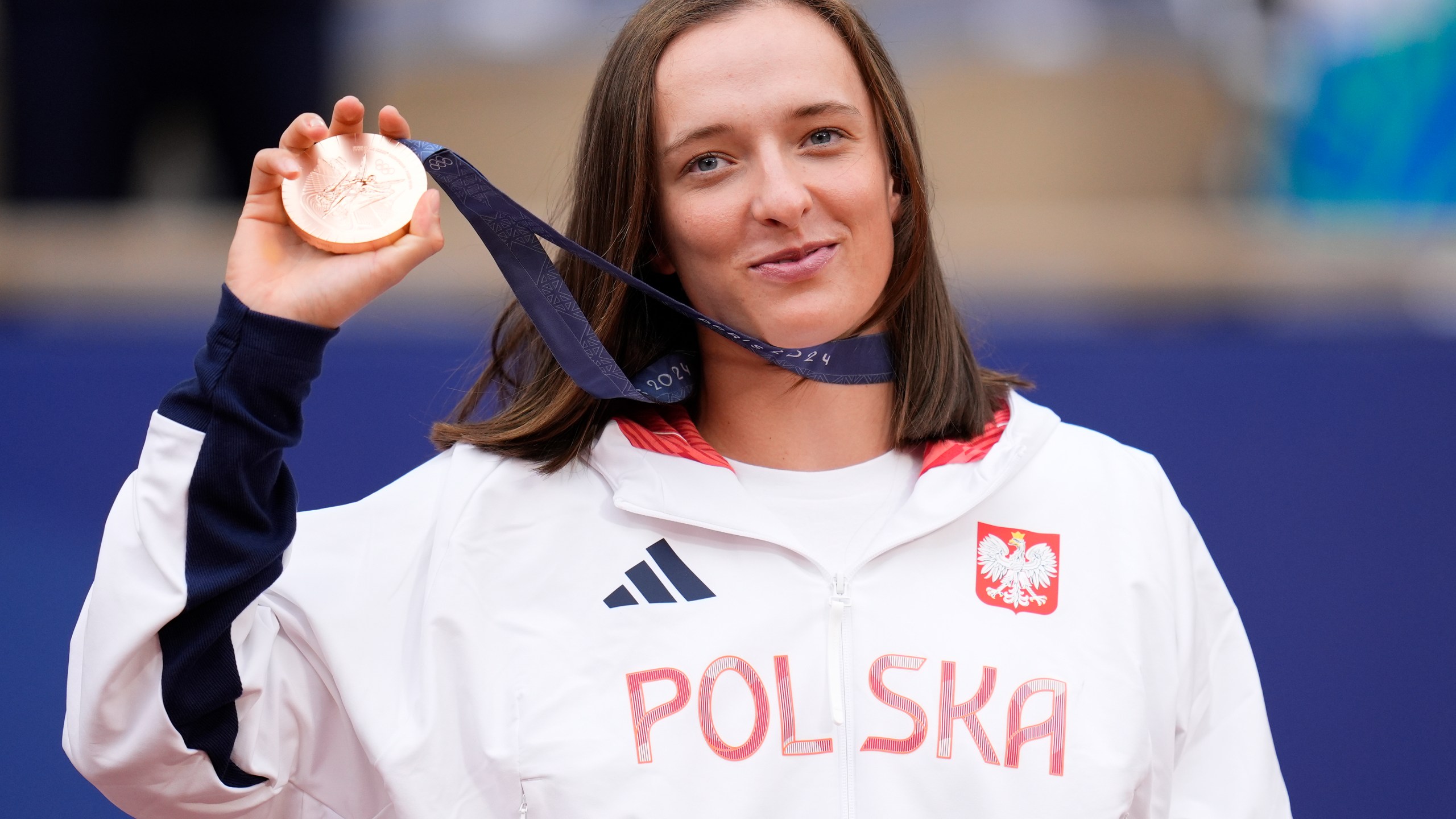 FILE - Poland's Iga Swiatek shows her bronze medal after the Women's Singles tennis final at the Roland Garros stadium at the 2024 Summer Olympics, Saturday, Aug. 3, 2024, in Paris, France. (AP Photo/Manu Fernandez, File)