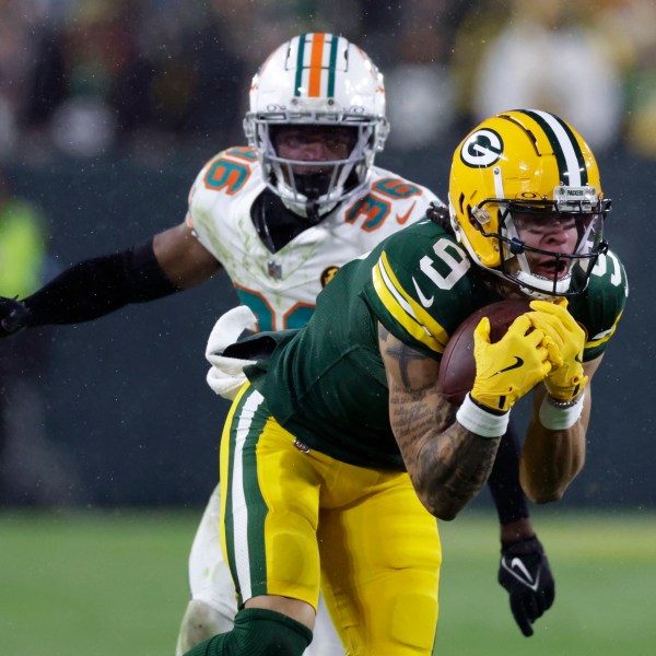 Green Bay Packers wide receiver Christian Watson (9) catches a pass ahead of Miami Dolphins cornerback Storm Duck (36) during the second half of an NFL football game Thursday, Nov. 28, 2024, in Green Bay, Wis. (AP Photo/Matt Ludtke)