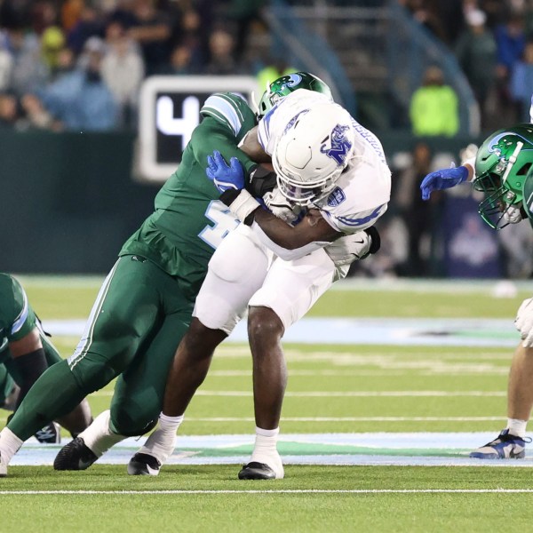 Tulane linebacker Chris Rodgers (4) tackles Memphis wide receiver Roc Taylor, center right, during the first half of an NCAA college football game in New Orleans, Thursday, Nov. 28, 2024. (AP Photo/Peter Forest)