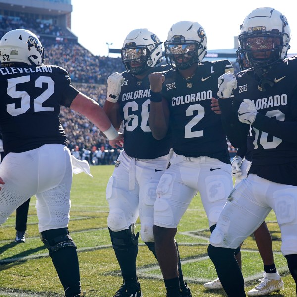 From left; Colorado offensive lineman Cash Cleveland celebrates with offensive lineman Justin Mayers after quarterback Shedeur Sanders tossed a touchdown pass to wide receiver LaJohntay Wester in the first half of an NCAA college football game against Oklahoma State Friday, Nov. 29, 2024, in Boulder, Colo. (AP Photo/David Zalubowski)