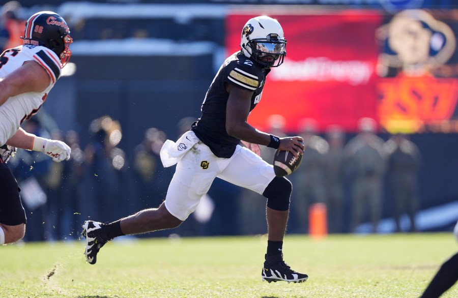 Colorado quarterback Shedeur Sanders avoids Oklahoma State safety Talon Kendrick in the first half of an NCAA college football game Friday, Nov. 29, 2024, in Boulder, Colo. (AP Photo/David Zalubowski)