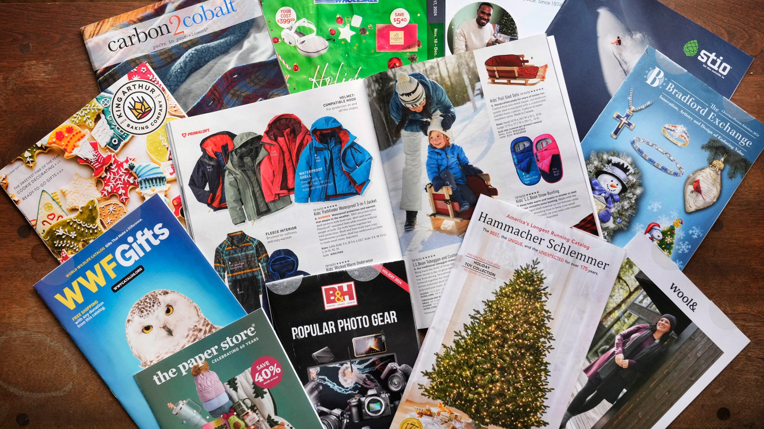 A collection of 2024 holiday catalogs are displayed Monday, Nov. 25, 2024, in Freeport, Maine. Catalog retailers, reeling from U.S. postal rate increases, have responded with pint-sized catalogs this holiday season. (AP Photo/Robert F. Bukaty)