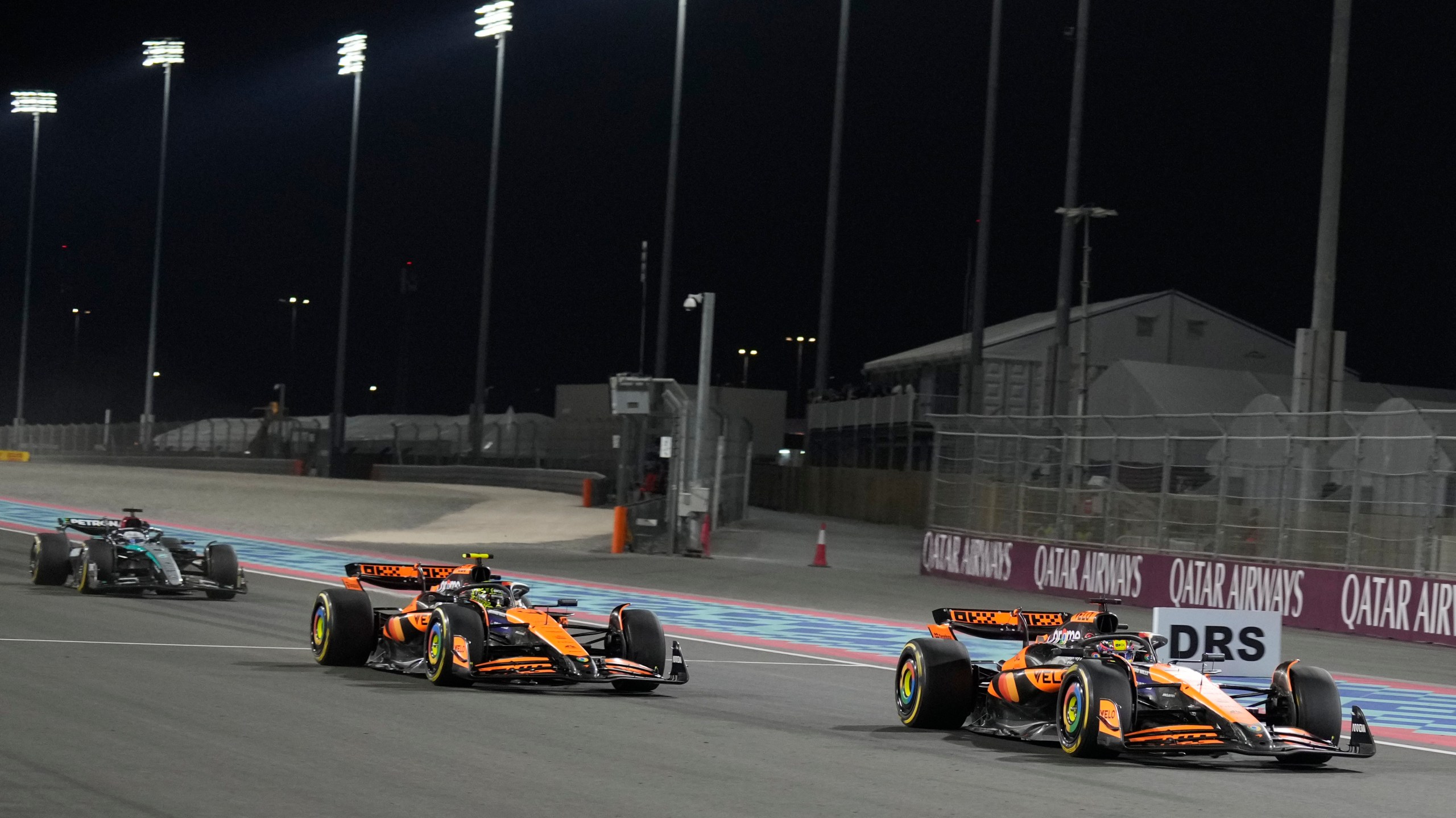 McLaren driver Oscar Piastri of Australia is about to cross the finish line followed by his teammate McLaren driver Lando Norris of Britain and Mercedes driver George Russell of Britain during sprint race at the Formula One Qatar Grand Prix, at the Lusail International Circuit in Lusail, Qatar, Saturday, Nov. 30, 2024. (AP Photo/Pool/ Altaf Qadri)