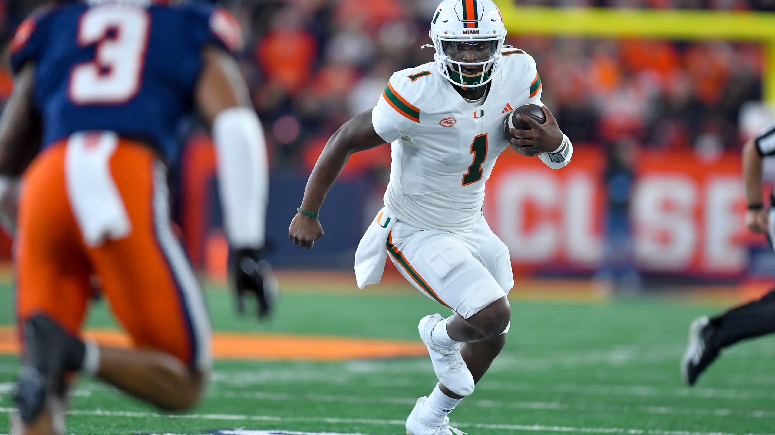 Miami quarterback Cam Ward (1) runs with the ball during the first half of an NCAA college football game against Syracuse on Saturday, Nov. 30, 2024 in Syracuse, N.Y. (AP Photo/Adrian Kraus)