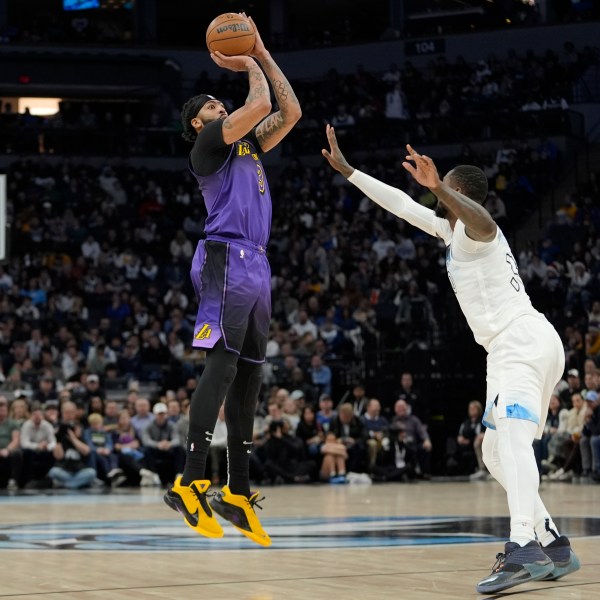 Los Angeles Lakers forward Anthony Davis (3), left, shoots over Minnesota Timberwolves forward Julius Randle (30) during the first half of an NBA basketball game, Monday, Dec. 2, 2024, in Minneapolis. (AP Photo/Abbie Parr)