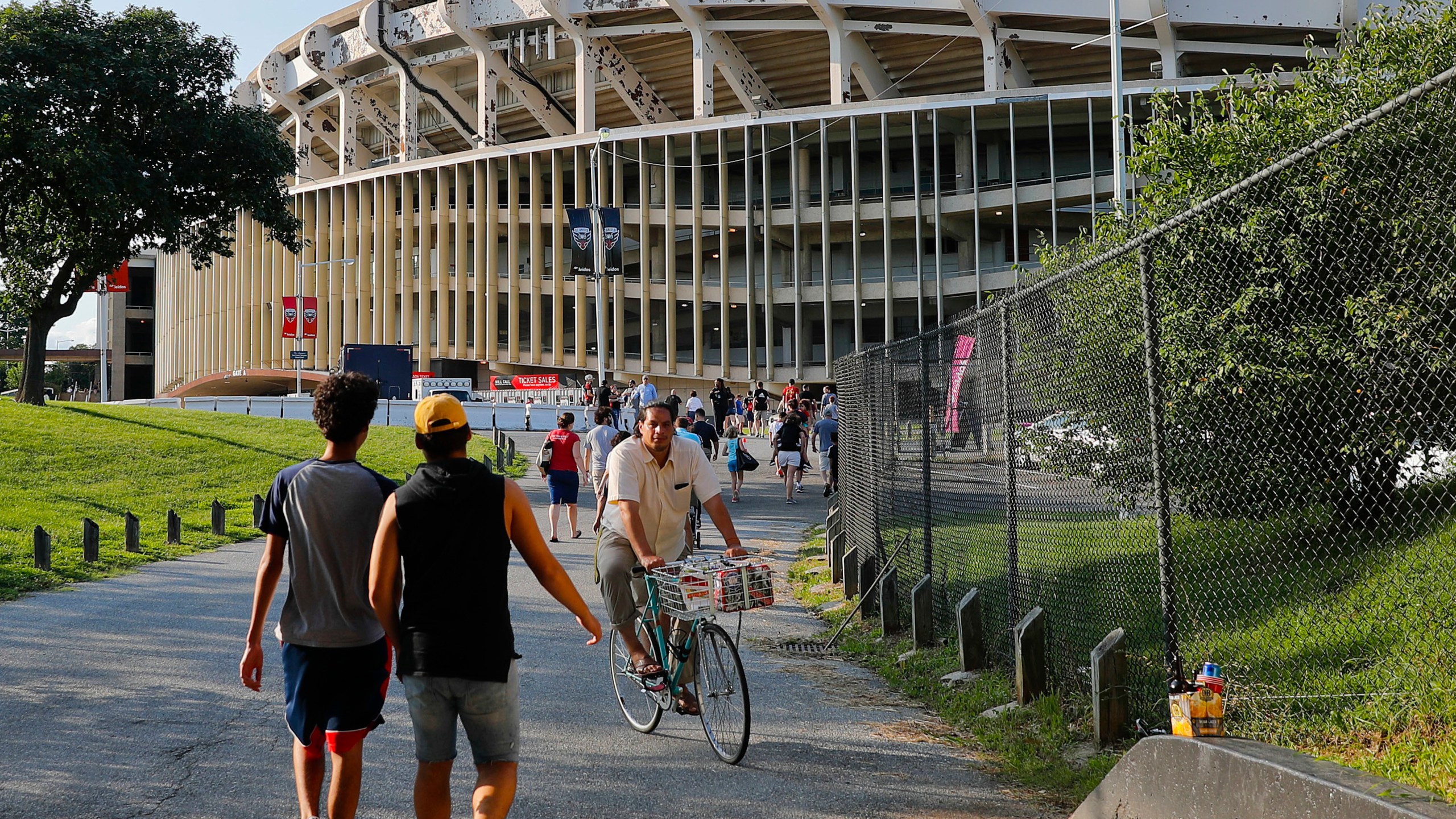 FILE - In this Aug. 5, 2017, file photo people make their way to RFK Stadium in Washington before an MLS soccer match between D.C. United and Toronto FC. (AP Photo/Pablo Martinez Monsivais, File)