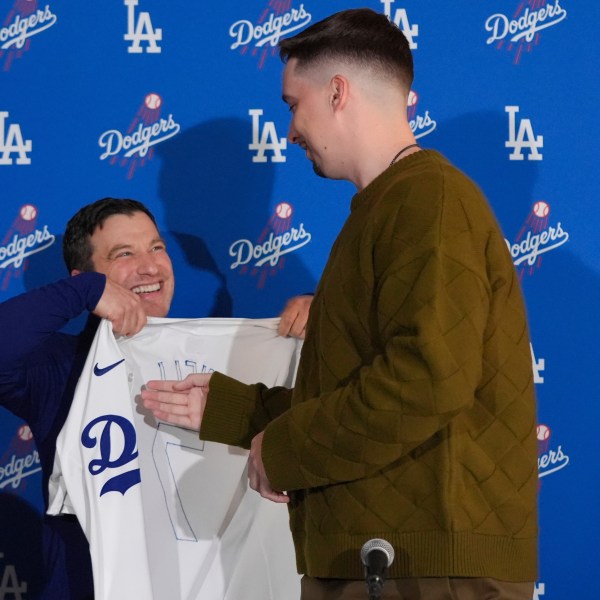 Los Angeles Dodgers pitcher Blake Snell, right, is presented with a jersey by president of baseball operations Andrew Friedman during a news conference Tuesday, Dec. 3, 2024, in Los Angeles. (AP Photo/Jae C. Hong)