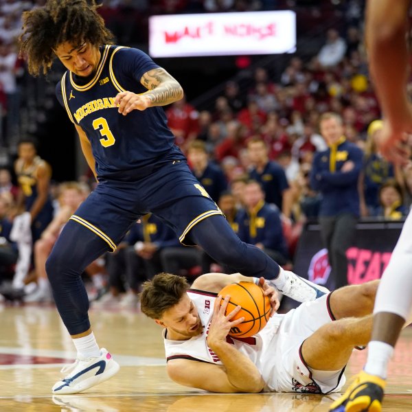 Wisconsin forward Carter Gilmore (7) dives for a loose ball against Michigan guard Tre Donaldson (3) during the first half of an NCAA college basketball game Tuesday, Dec. 3, 2024, in Madison, Wis. (AP Photo/Kayla Wolf)