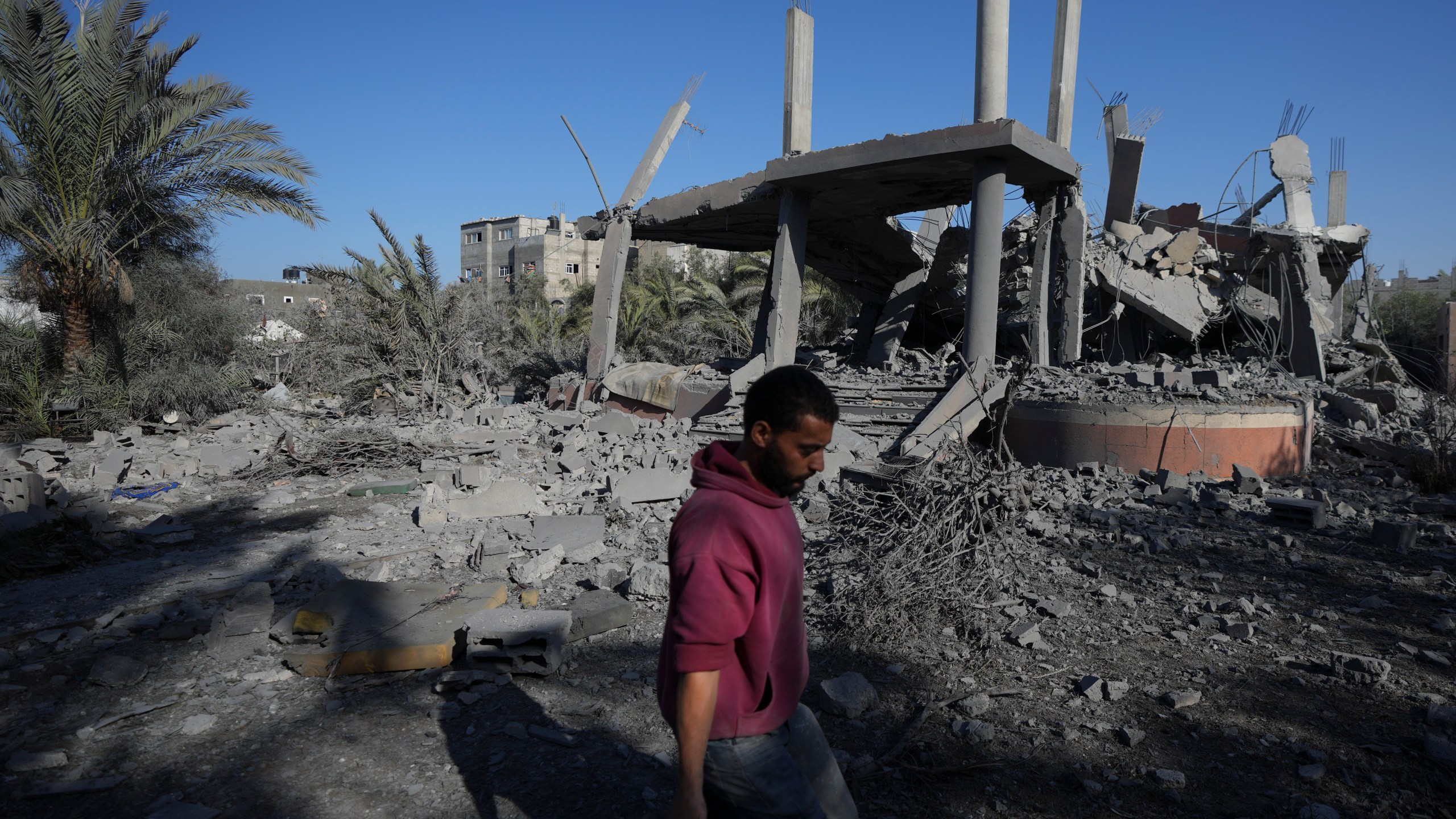 A Palestinian walks past a destroyed building following an overnight Israeli strike in Deir al-Balah, Gaza Strip, Wednesday, Dec. 4, 2024. (AP Photo/Abdel Kareem Hana)