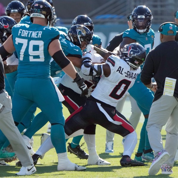 Players fight after Houston Texans linebacker Azeez Al-Shaair (0) hit Jacksonville Jaguars quarterback Trevor Lawrence with a late hit during the first half of an NFL football game Sunday, Dec. 1, 2024, in Jacksonville, Fla. (AP Photo/John Raoux)