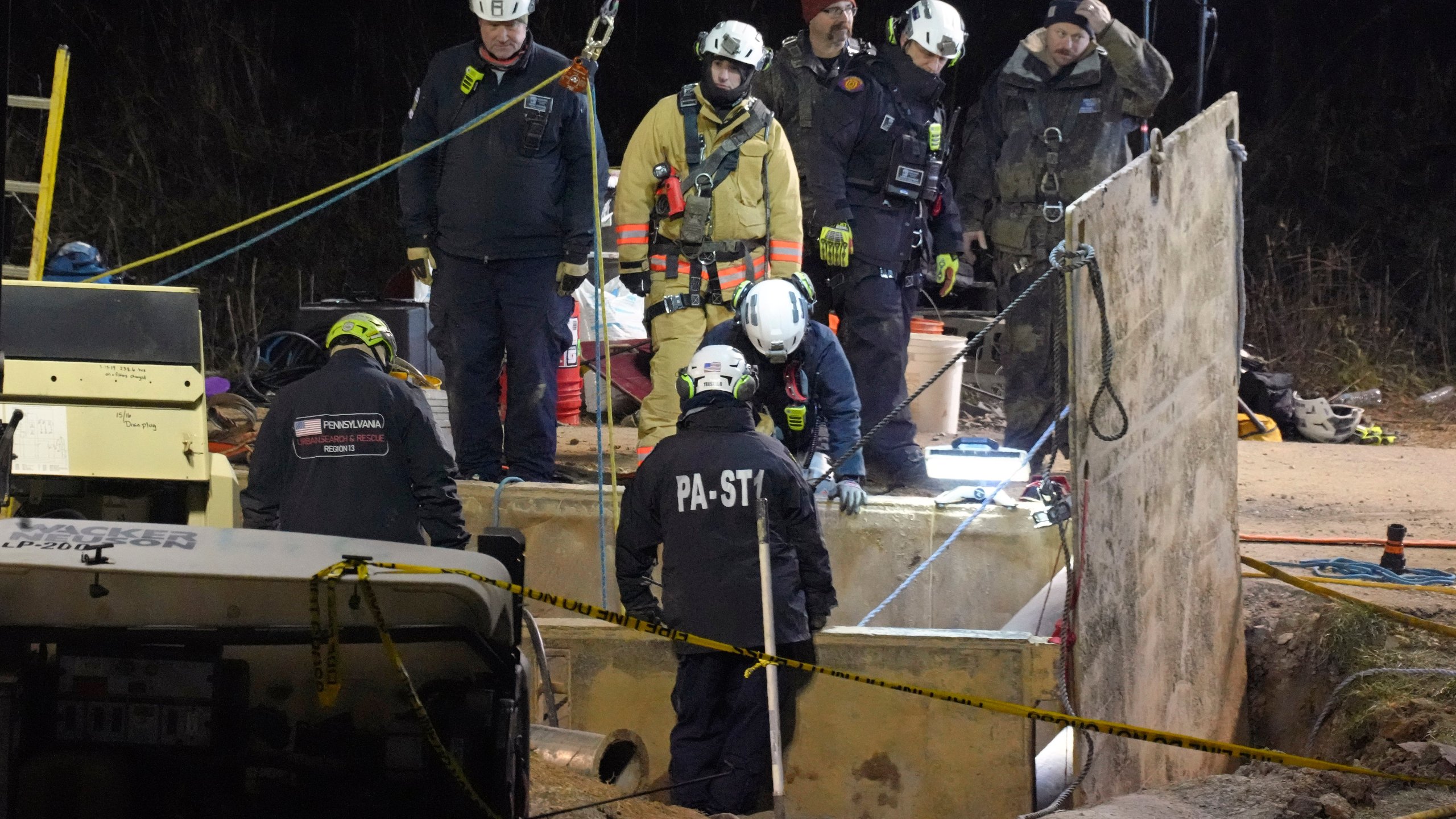 Rescue workers search through the night in a sinkhole for Elizabeth Pollard, who disappeared while looking for her cat, in Marguerite, Pa., Tuesday, Dec. 3, 2024. (AP Photo/Gene J. Puskar)