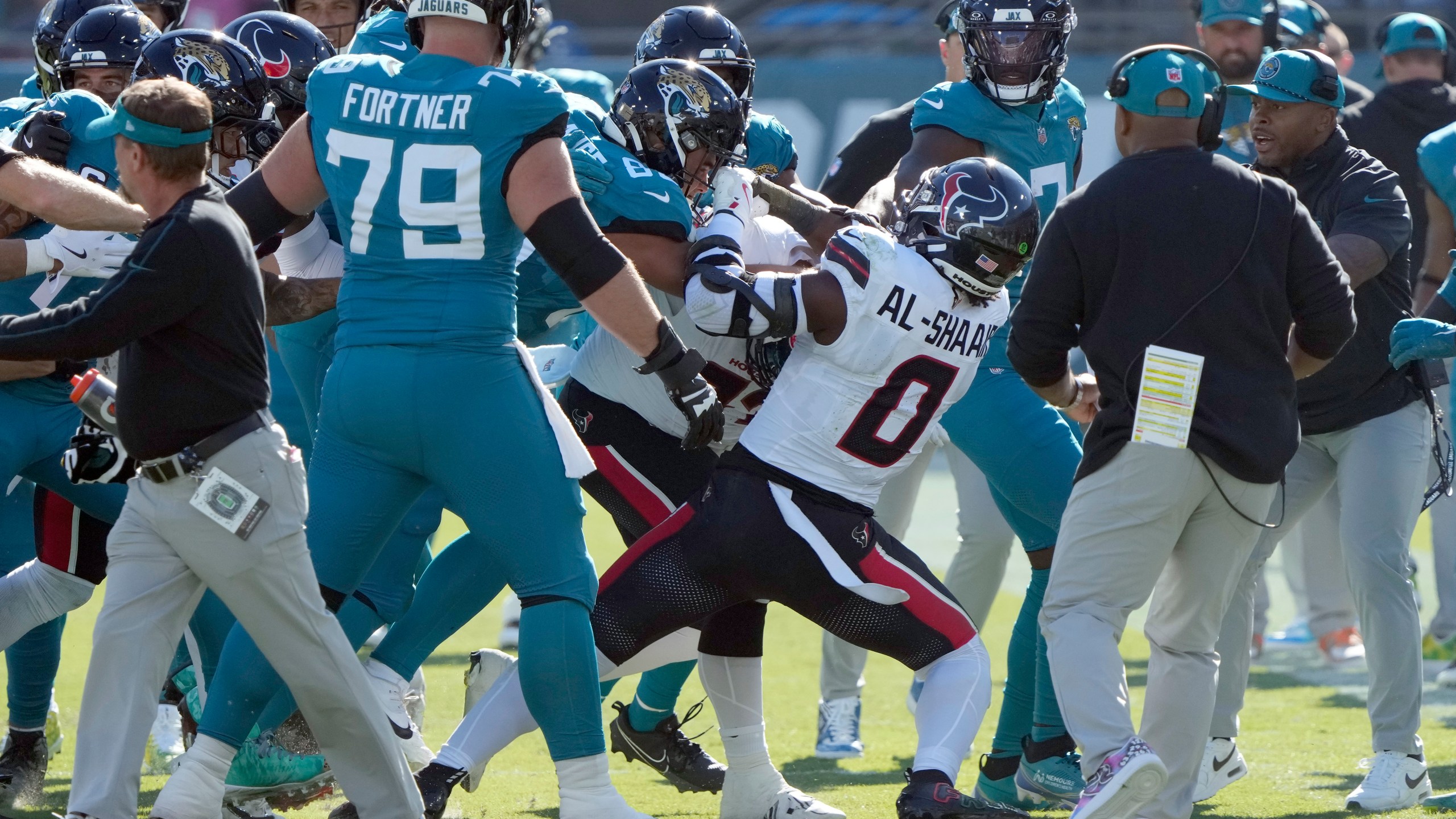 Players fight after Houston Texans linebacker Azeez Al-Shaair (0) hit Jacksonville Jaguars quarterback Trevor Lawrence with a late hit during the first half of an NFL football game Sunday, Dec. 1, 2024, in Jacksonville, Fla. (AP Photo/John Raoux)