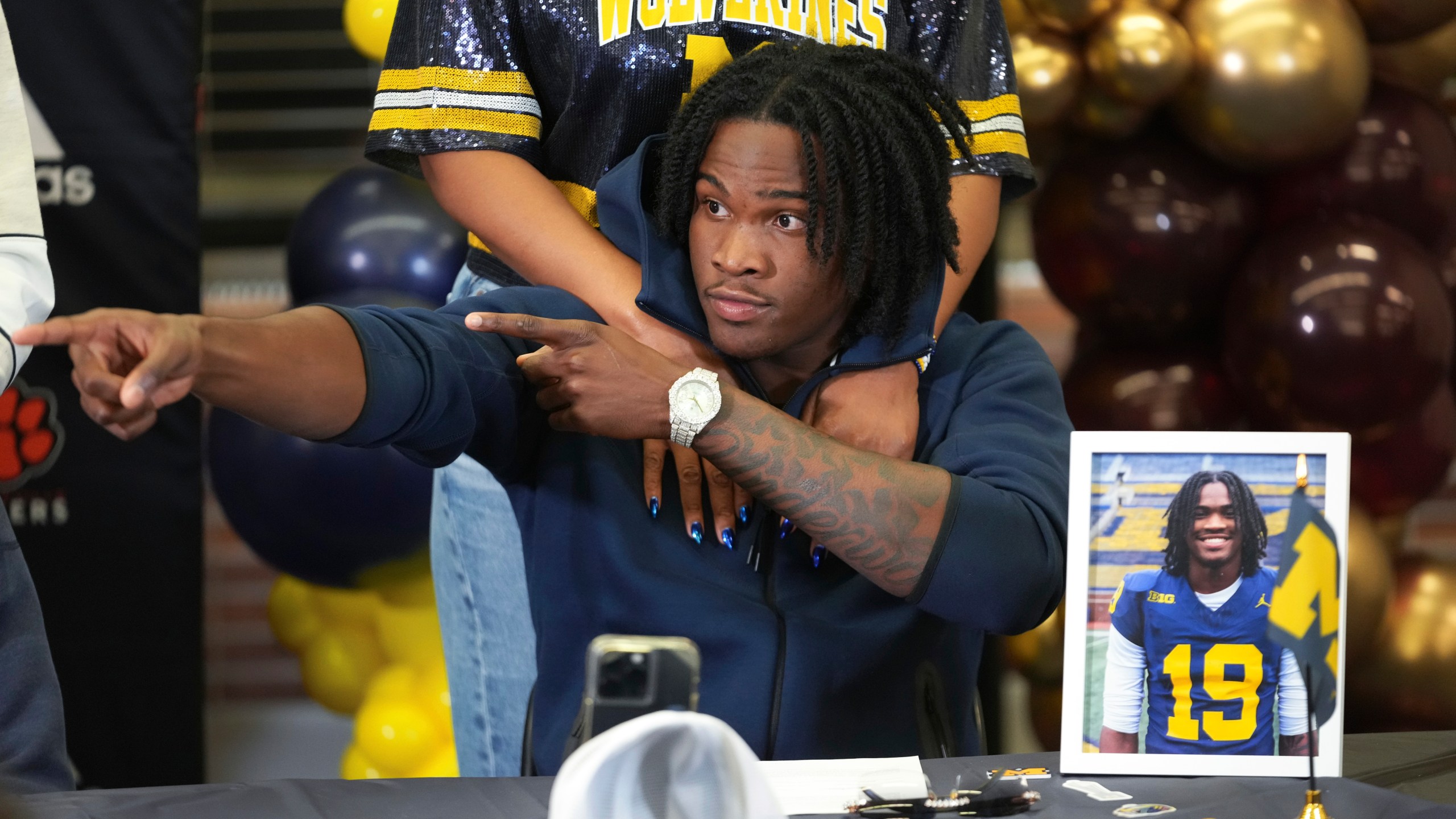 Belleville High School quarterback Bryce Underwood reacts after signing to play NCAA football at Michigan during a news conference in Belleville, Mich., Wednesday, Dec. 4, 2024. (AP Photo/Paul Sancya)