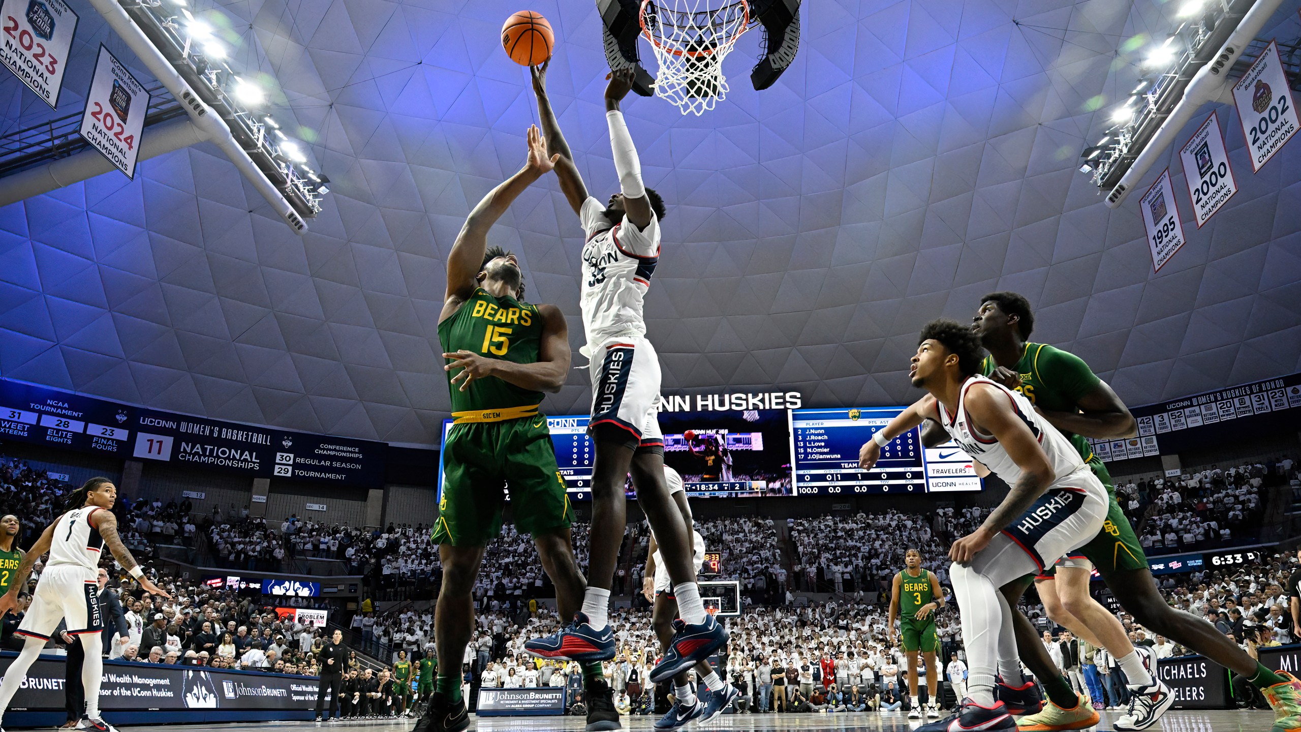 UConn center Samson Johnson (35) blocks a shot by Baylor forward Norchad Omier (15) in the first half of an NCAA college basketball game, Wednesday, Dec. 4, 2024, in Storrs, Conn. (AP Photo/Jessica Hill)