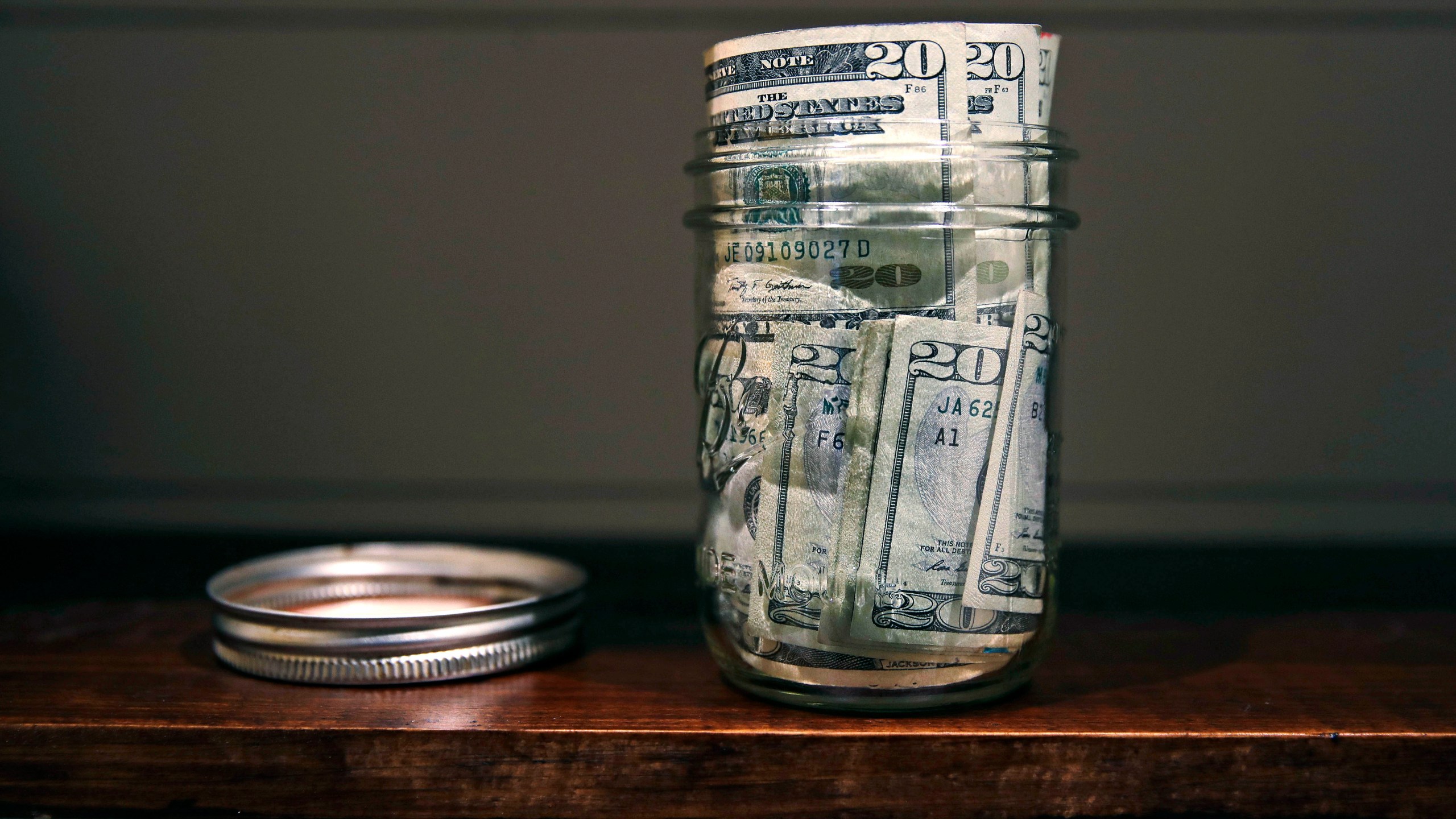 FILE - A canning jar filled with money sits on a shelf in East Derry, N.H., June 15, 2018. (AP Photo/Charles Krupa, File)