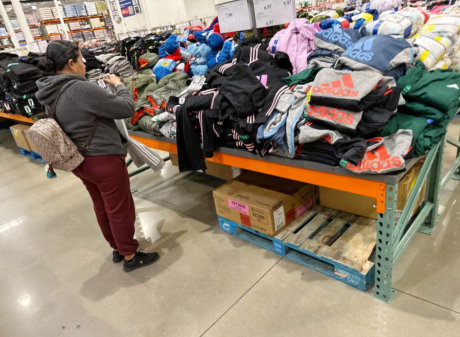 A shopper looks over clothing on display in a Costco warehouse Wednesday, Dec. 4, 2024, in Sheridan, Colo. (AP Photo/David Zalubowski)